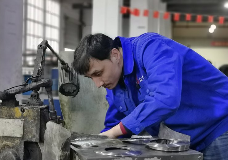 Factory worker manufacturing an industrial machine knife